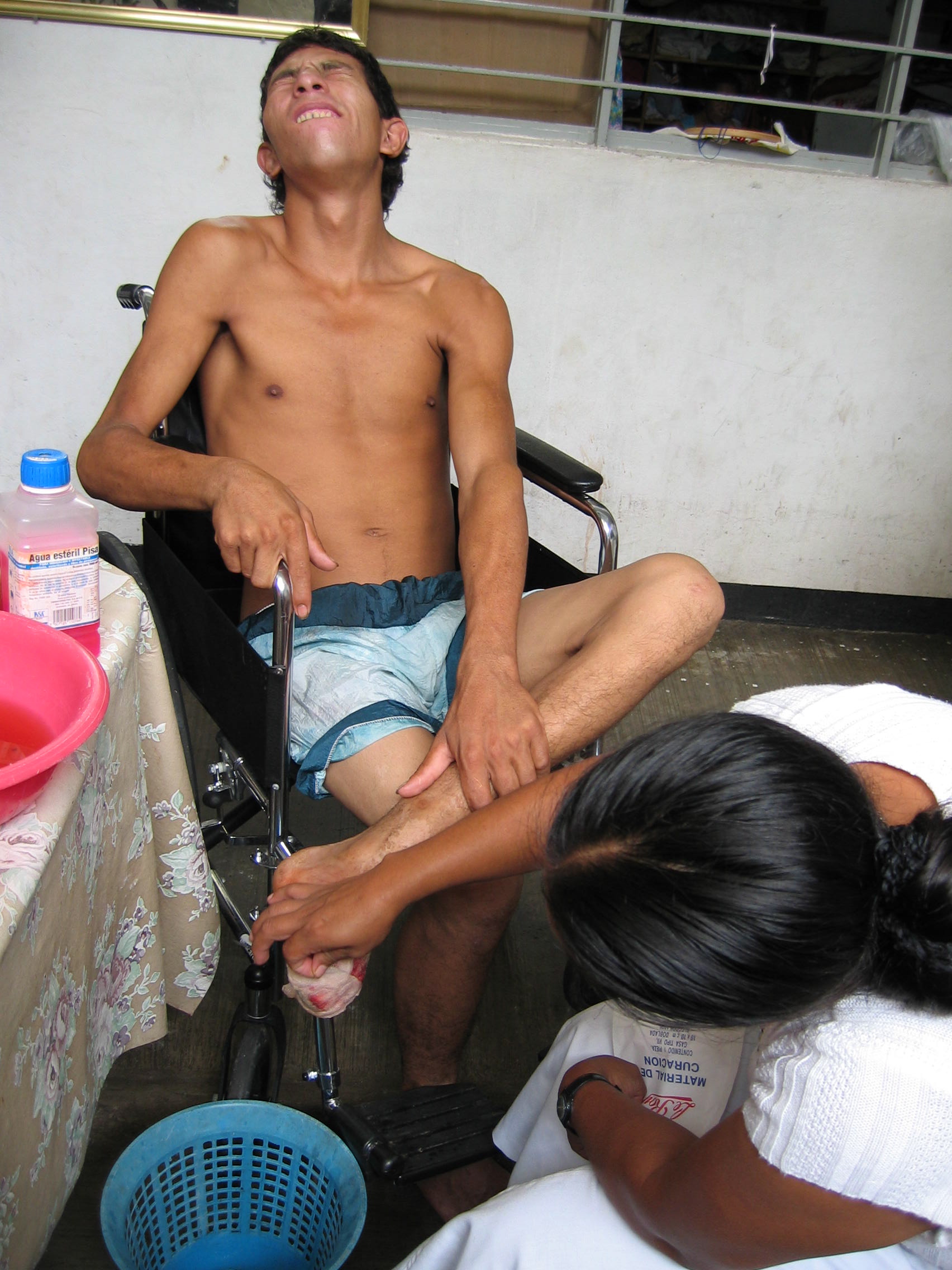 Each day, shelter director Olga Sánchez Martínez cleans and dresses migrants' wounds. Fausto Mejillas Guerrero, from Honduras, lost half a foot to the train.