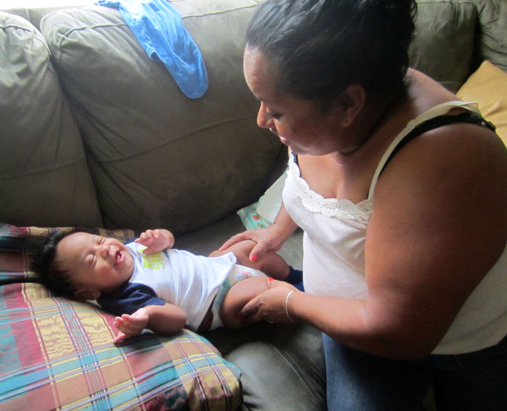 Enrique's mother Lourdes dotes on Enrique's son, Daniel Enrique. She gives his son the love she could not give Enrique when he was growing up in Honduras. [Credit: Sonia Nazario]